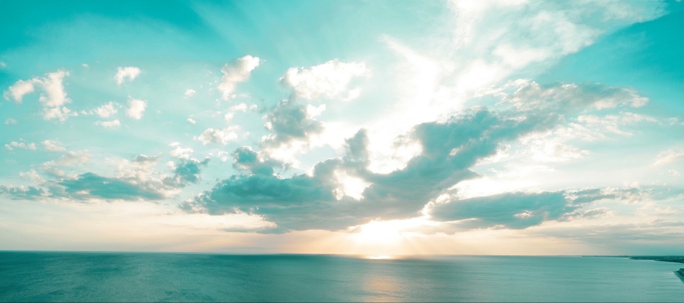 Sun breaking through clouds over the sea
